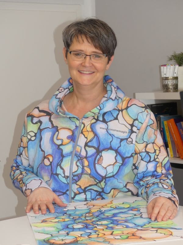 Frau mit buntem Hoody lächelt in die Kamera